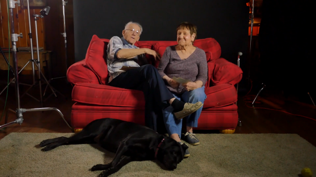 Allen and Rosemary Allen and Rosemary on the couch with black dog at their feet.