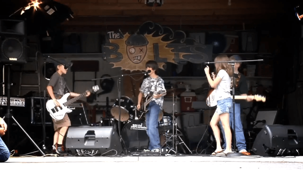 Child musicians playing together in the garage.